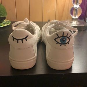 white sneakers with eye details.